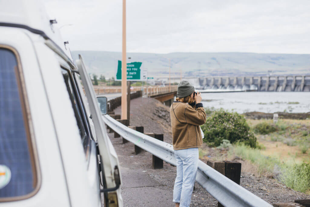 Girl takes a picture next to a Volkswagen Vanagon Camper.