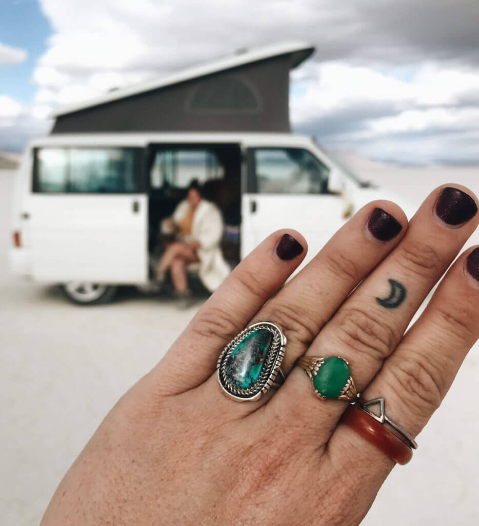 Woman holds up her hand, Eurovan Camper in the background, Alvord Desert.